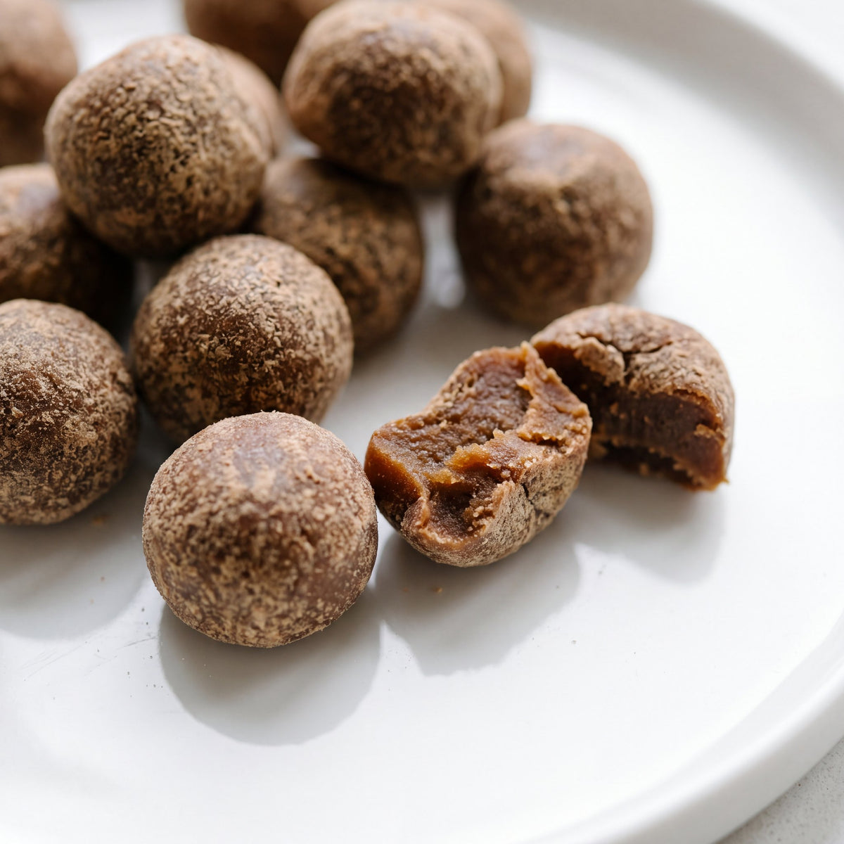 Soft round beef-flavoured dog probiotic chews on a plate, one broken open
